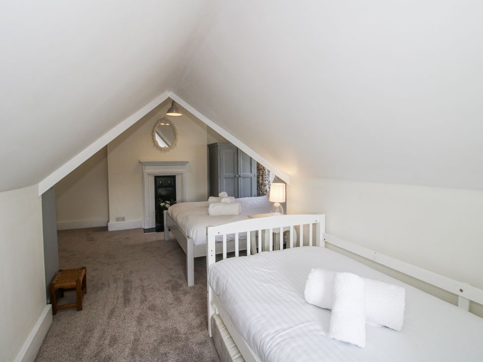 A bedroom with two beds and a mirror at The Old Vicarage Kimbolton near Leominster