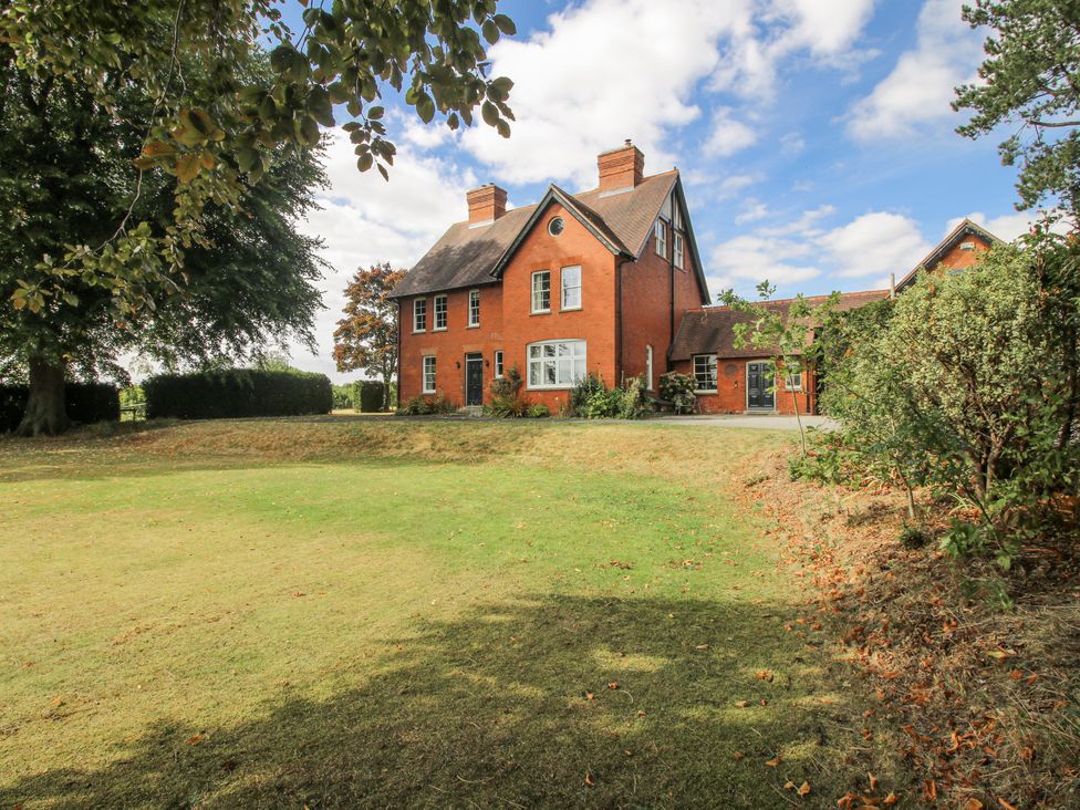 A house with a lawn and trees at The Old Vicarage Kimbolton near Leominster