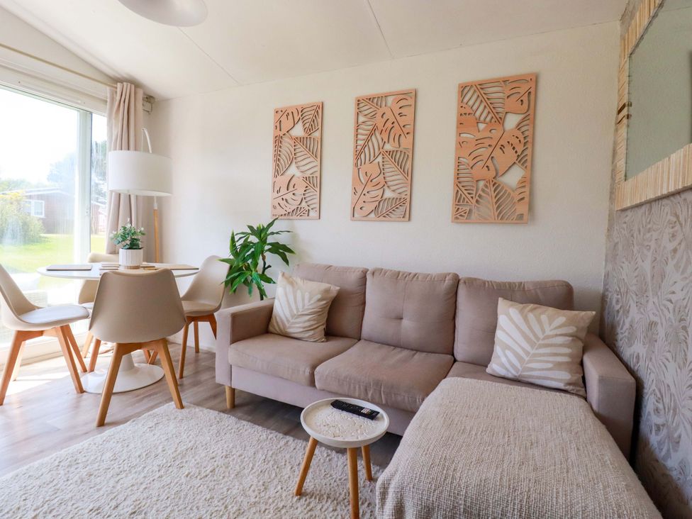 A living room with a sofa and dining table at Cozy Retreat in Tregolds