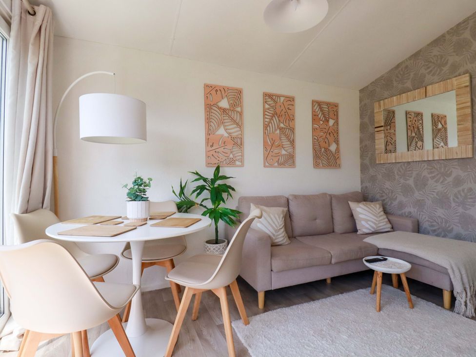 A living room with a table and chairs at Cozy Retreat in Tregolds