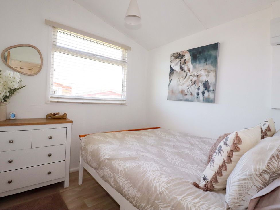 A bedroom with a bed and dresser at Cozy Retreat in Tregolds