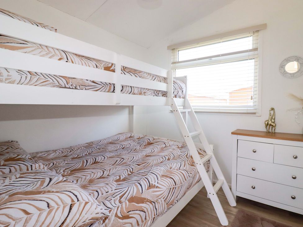 A bedroom with a bunk bed and dresser at Cozy Retreat in Tregolds