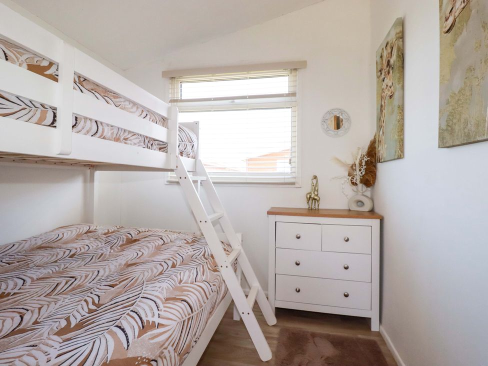 A bedroom with a bunk bed and dresser at Cozy Retreat in Tregolds