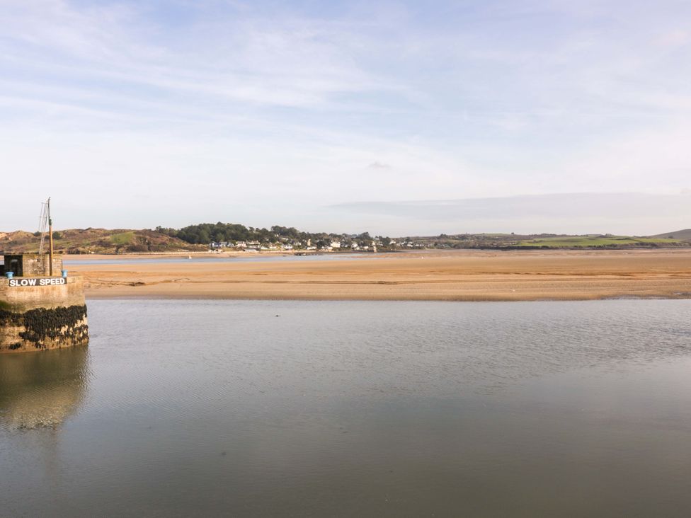 A view of a river with a sand bank and a pier at Cozy Retreat in Tregolds