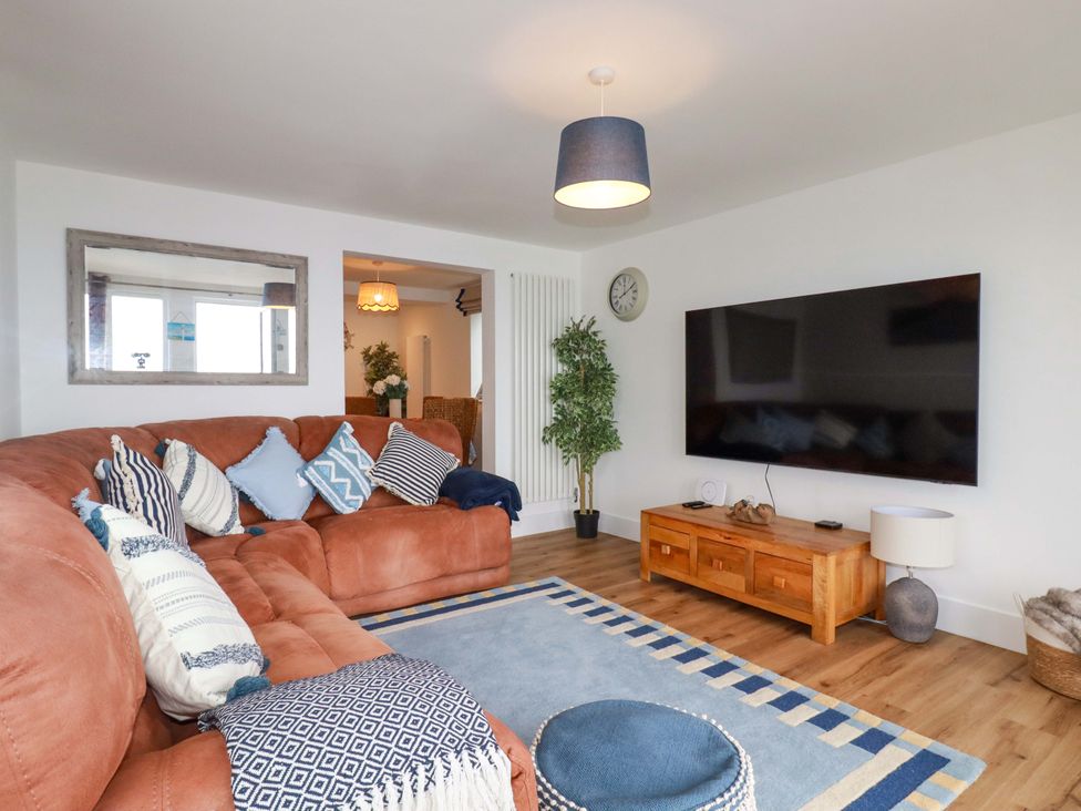 A living room with a sofa and television at Ocean Edge in Sennen Cove