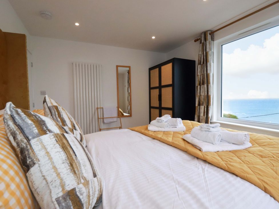 A bedroom with a bed and wardrobe at Ocean Edge in Sennen Cove
