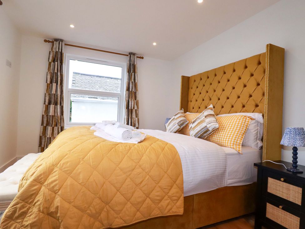 A bedroom with a bed and window at Ocean Edge Sennen Cove