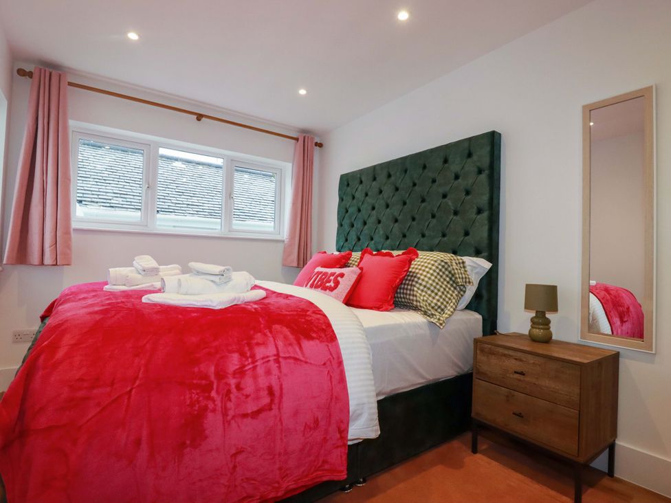 A bedroom with a large bed and a nightstand at Ocean Edge in Sennen Cove