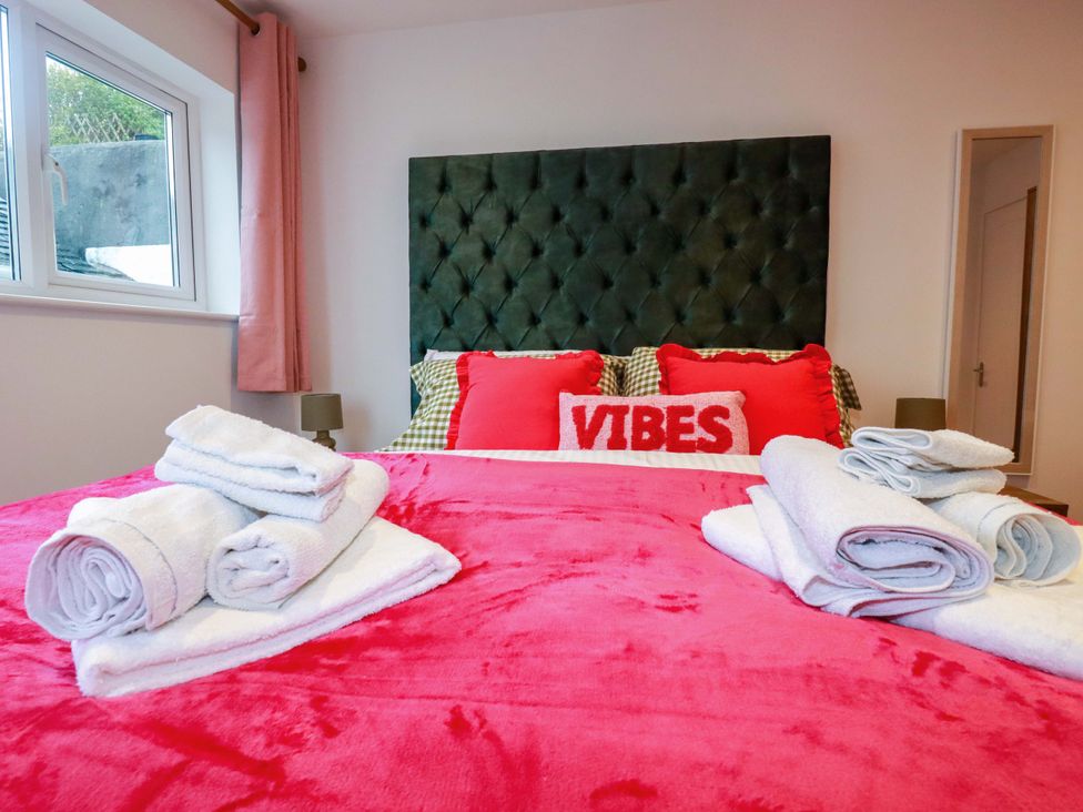 A bedroom with a bed and towels at Ocean Edge in Sennen Cove