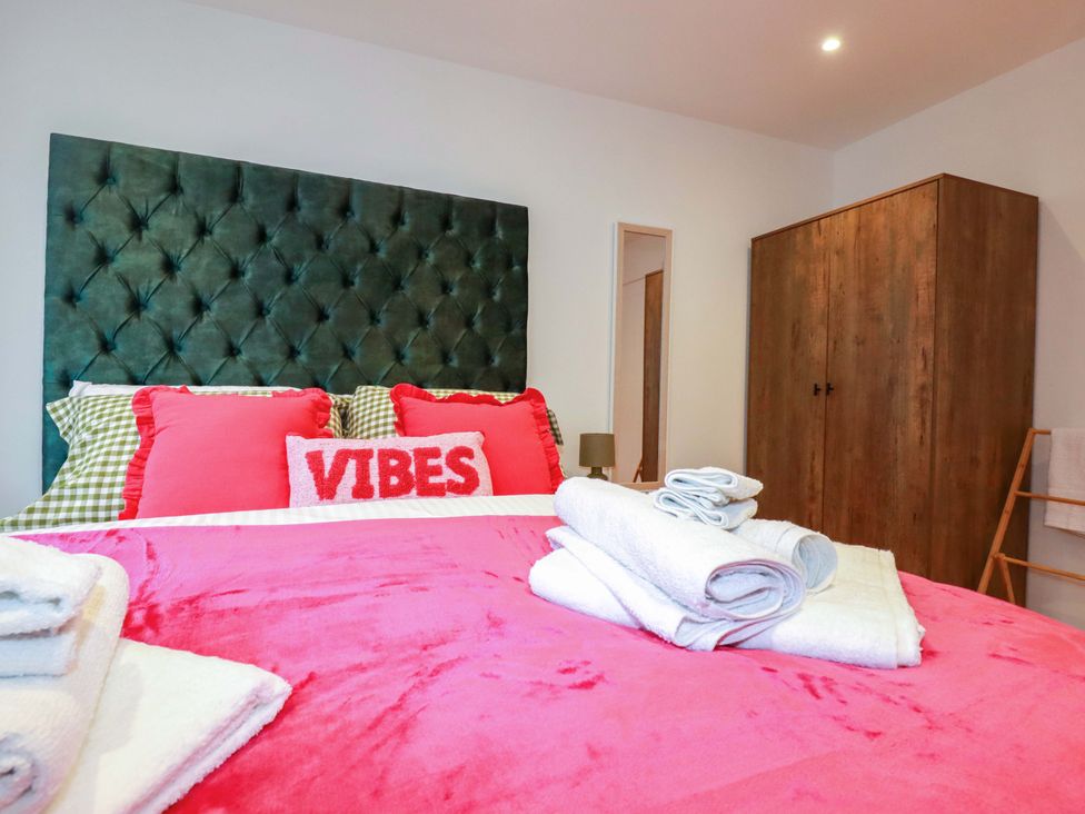 A bedroom with a bed and a wardrobe at Ocean Edge in Sennen Cove