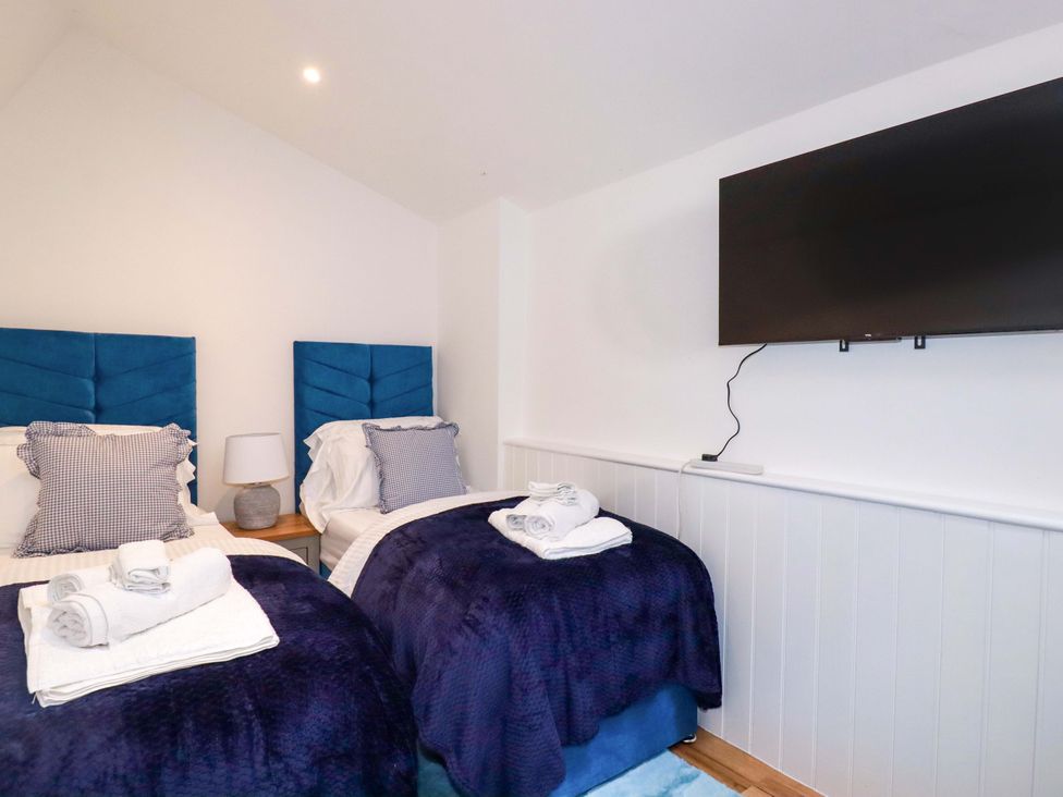 A bedroom with two beds and a television at Ocean Edge in Sennen Cove