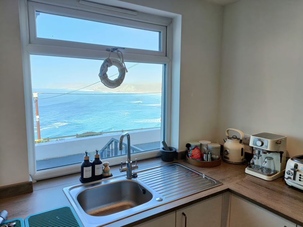 A kitchen with a sink and coffee maker at Ocean Edge in Sennen Cove