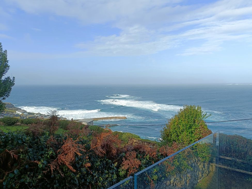 An ocean view with waves and vegetation at Ocean Edge Sennen Cove