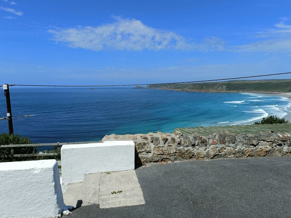 A coastal view with ocean waves and a wall at Ocean Edge in Sennen Cove
