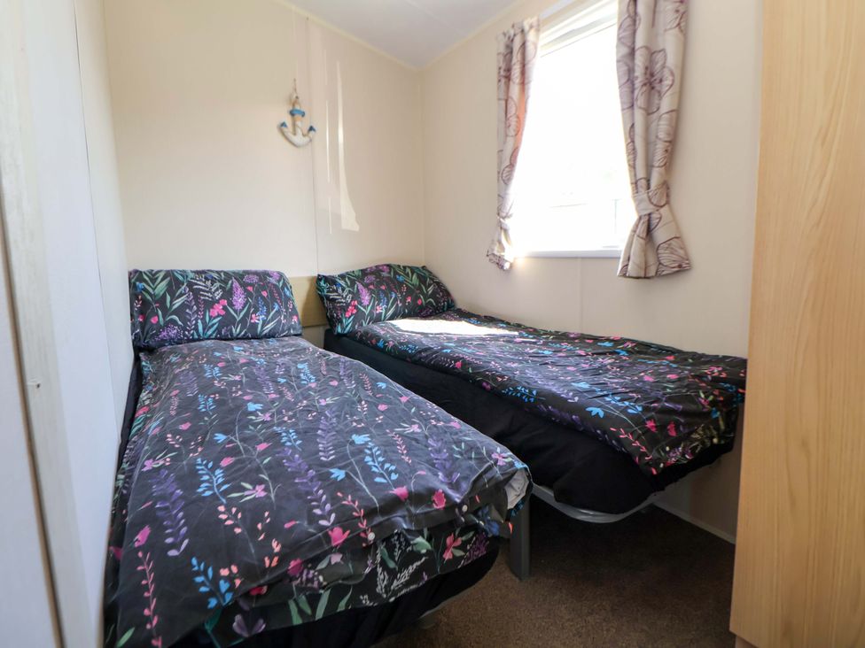 A bedroom with two single beds and a window at Willerby Aurora B14 Towyn