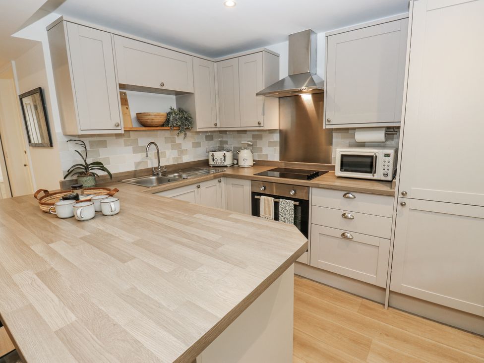 A kitchen with cabinets, sink, stove and microwave at Apartment 5 in Skipton