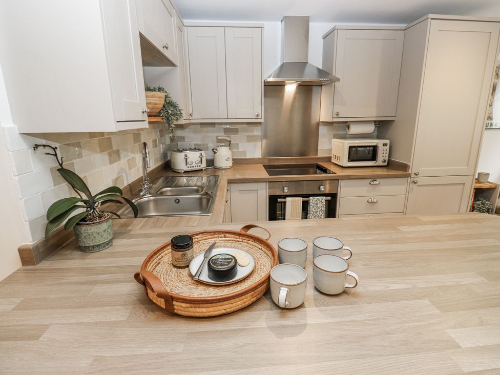A kitchen with cabinets and a tray of mugs at Apartment 5 in Skipton