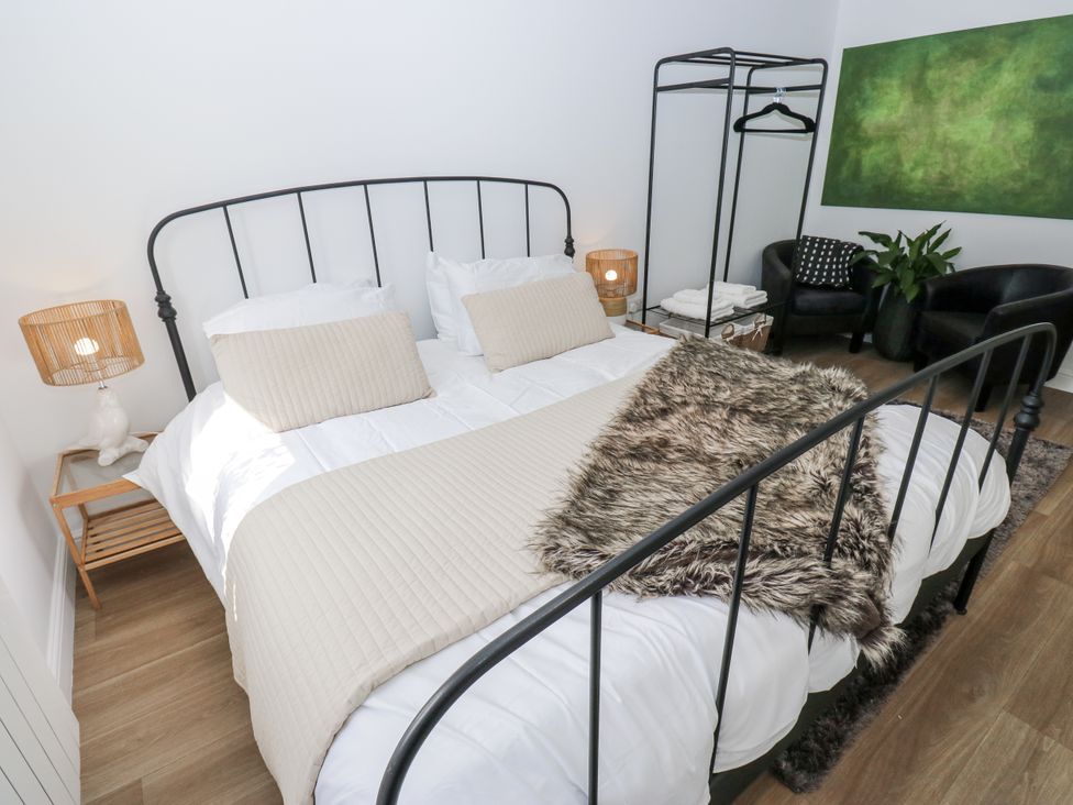 A bedroom with a bed and a clothing rack at Apartment 5 Skipton