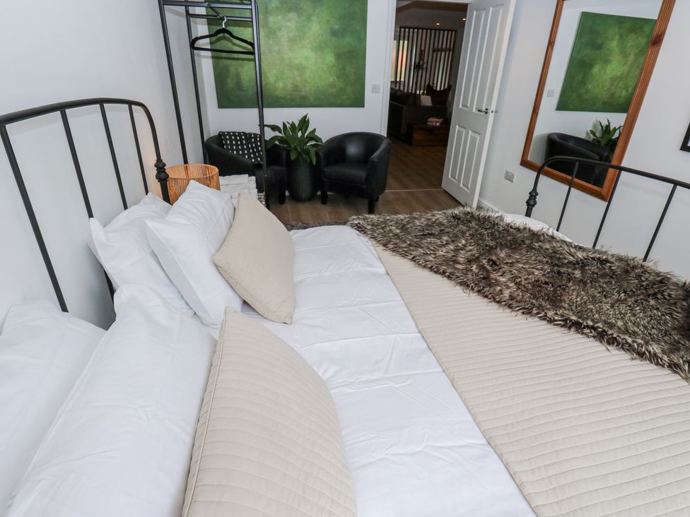 A bedroom with a bed and coat rack at Apartment 5 in Skipton