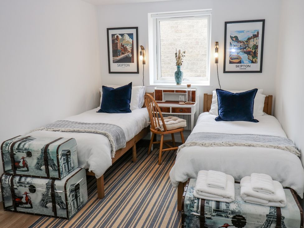 A bedroom with two beds and a desk at Apartment 5 in Skipton