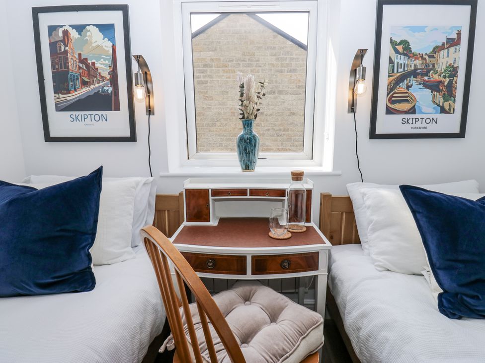 A bedroom with two beds and a desk at Apartment 5 Skipton