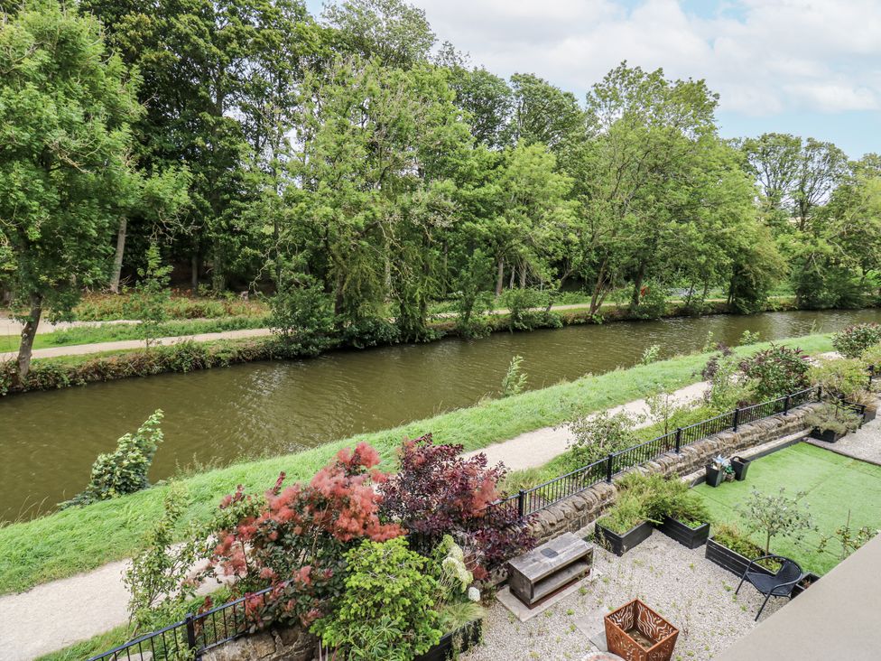 A view of a river with trees and plants at Apartment 5 in Skipton