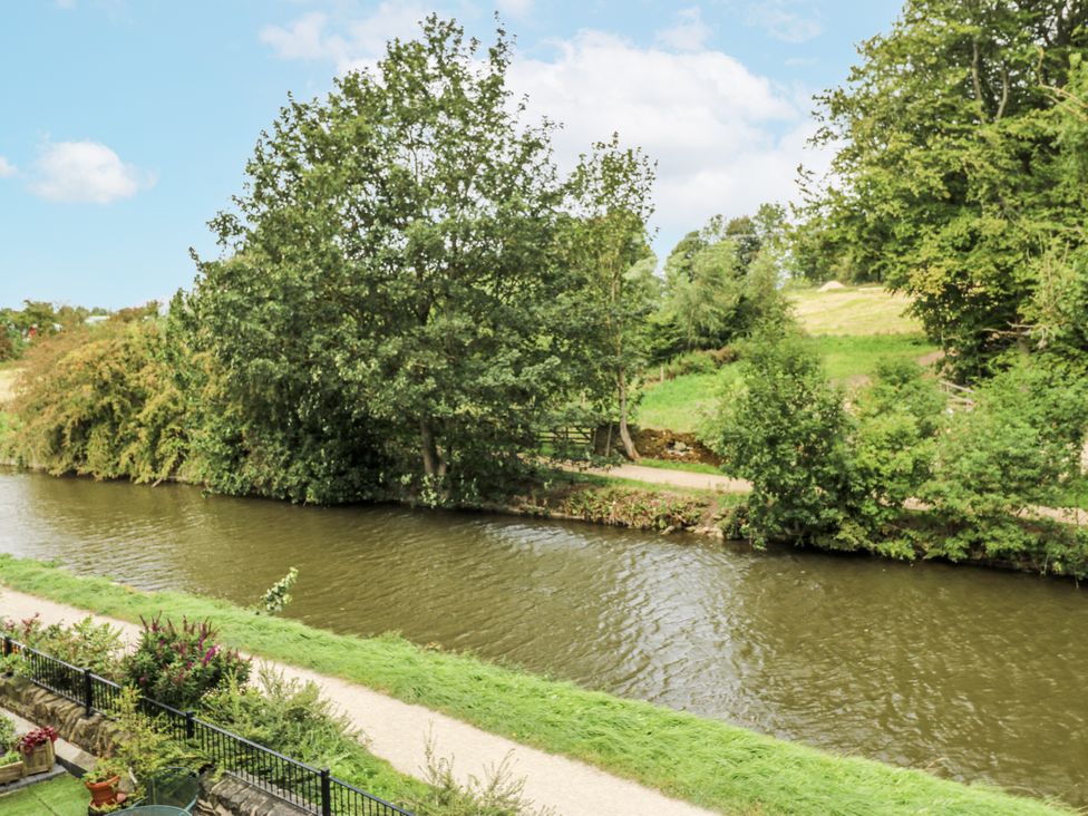 A view of a river with trees and a pathway at Apartment 5 in Skipton