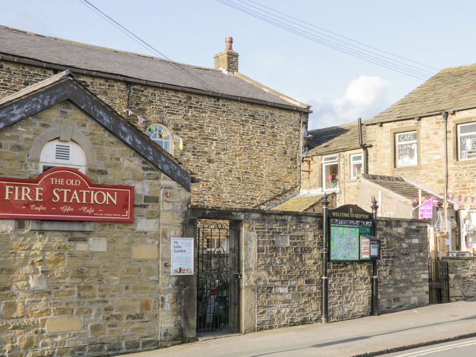 A building with a sign for The Old Fire Station and a welcome map in Skipton