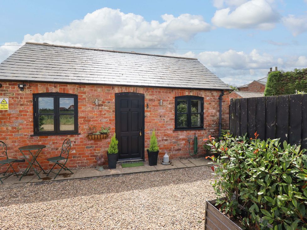 A cottage exterior with outdoor furniture and plants at The Paw Barn in Scrane End near Boston