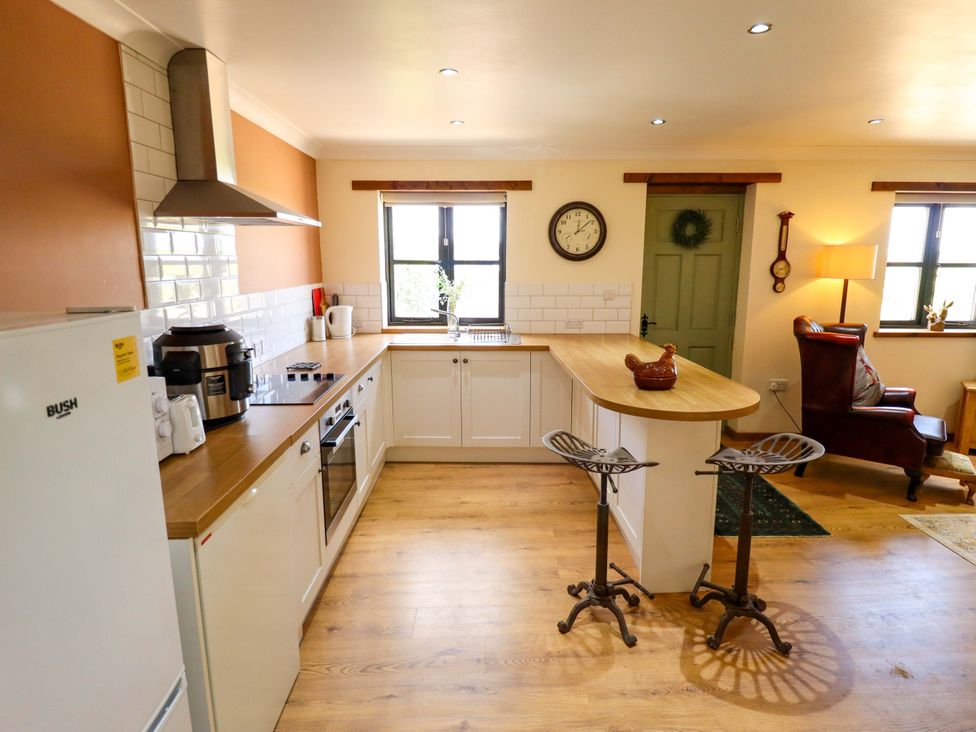 A kitchen with appliances and seating at The Paw Barn in Scrane End near Boston