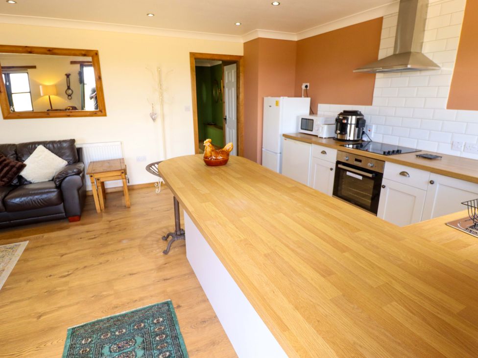 A kitchen with a counter, appliances, and a sofa at The Paw Barn in Scrane End near Boston