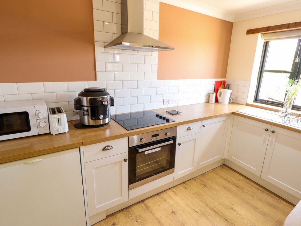 A kitchen with a microwave, toaster, air fryer, and stove at The Paw Barn in Scrane End near Boston