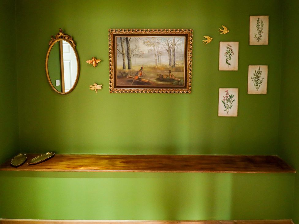 An entryway with a mirror, painting, and decorative items at The Paw Barn in Scrane End near Boston