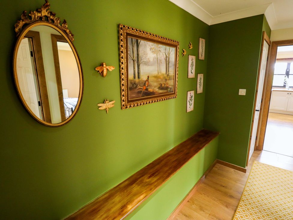 A hallway with a mirror and painting on the wall at The Paw Barn in Scrane End near Boston