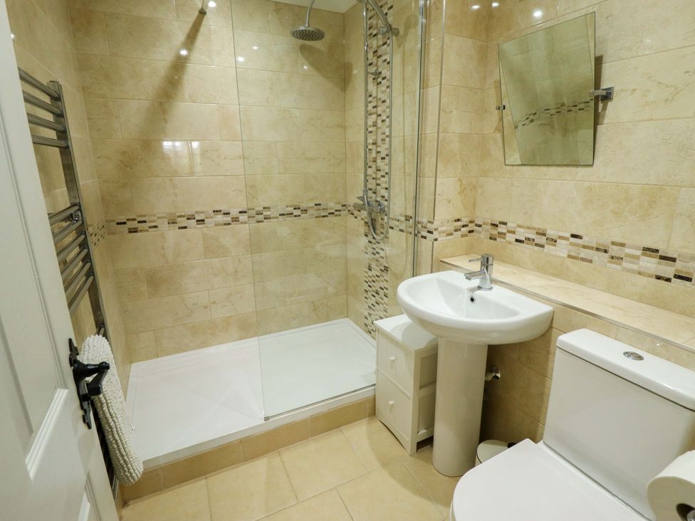 A bathroom with a shower, sink, and toilet at The Paw Barn in Scrane End near Boston