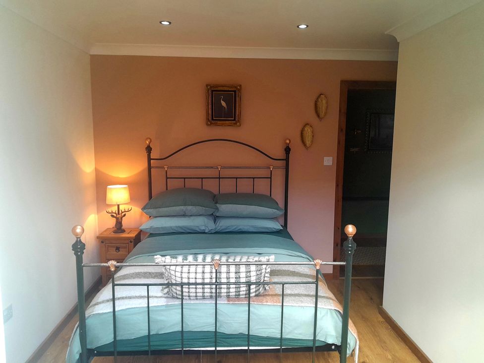 A bedroom with a bed and nightstand at The Paw Barn in Scrane End near Boston
