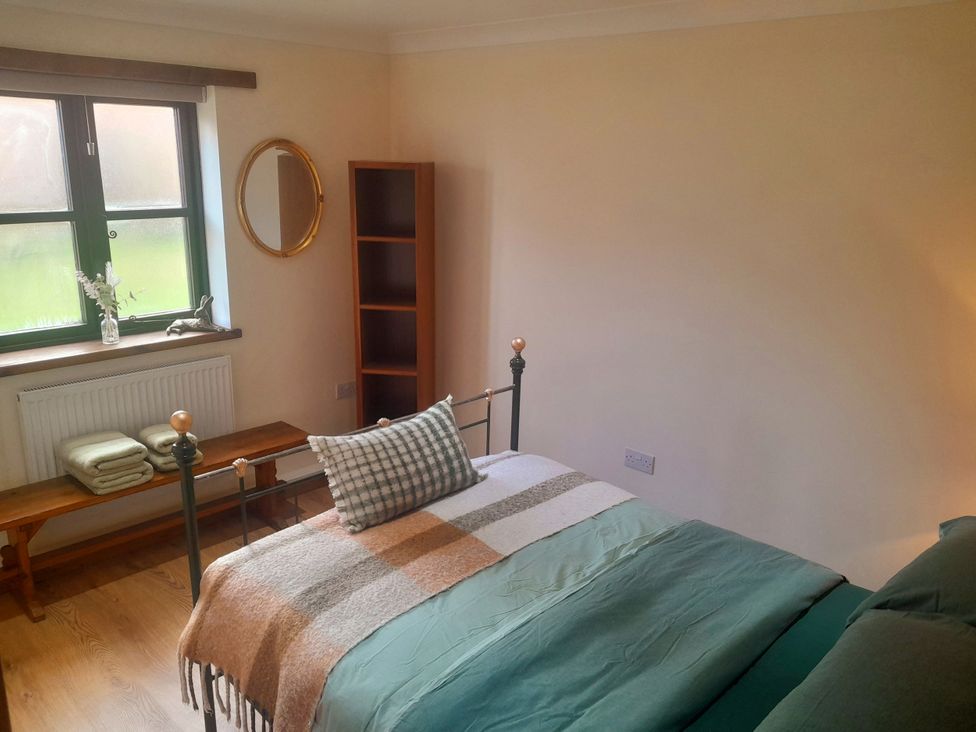 A bedroom with a bed and bookshelf at The Paw Barn near Boston
