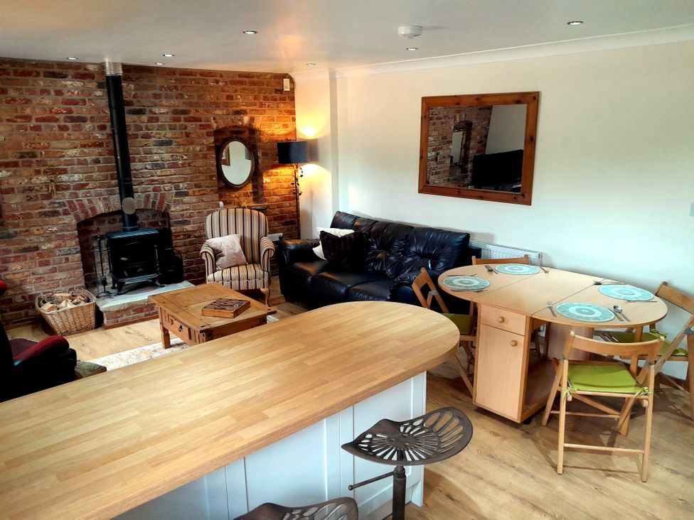 A living room with a fireplace and seating area at The Paw Barn in Scrane End near Boston