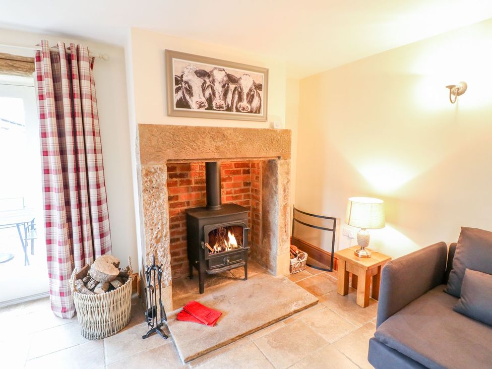 A living room with a wood stove and a sofa at The Barn in Wirksworth