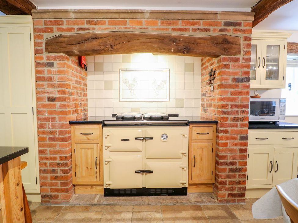 A kitchen with a brick wall and a cooker at The Barn in Wirksworth