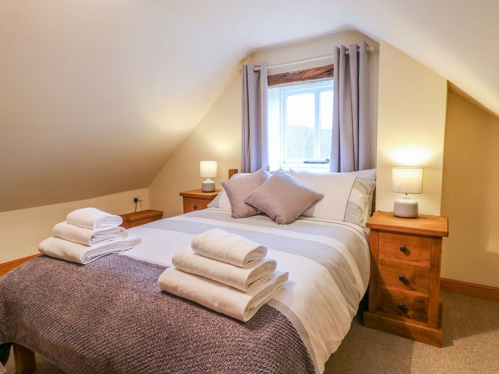 A bedroom with a bed and bedside tables at The Barn in Wirksworth
