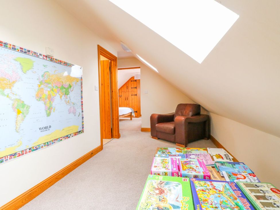 A landing with a world map and books at The Barn in Wirksworth