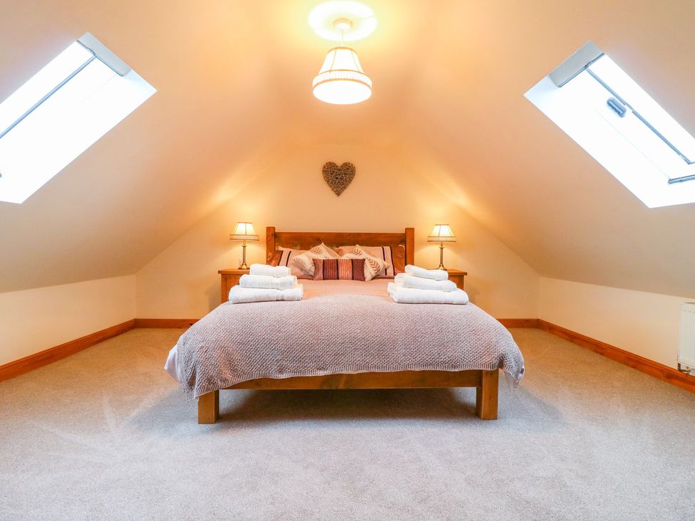 A bedroom with a bed and towels at The Barn in Wirksworth