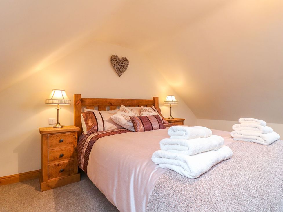 A bedroom with a bed and nightstand at The Barn in Wirksworth