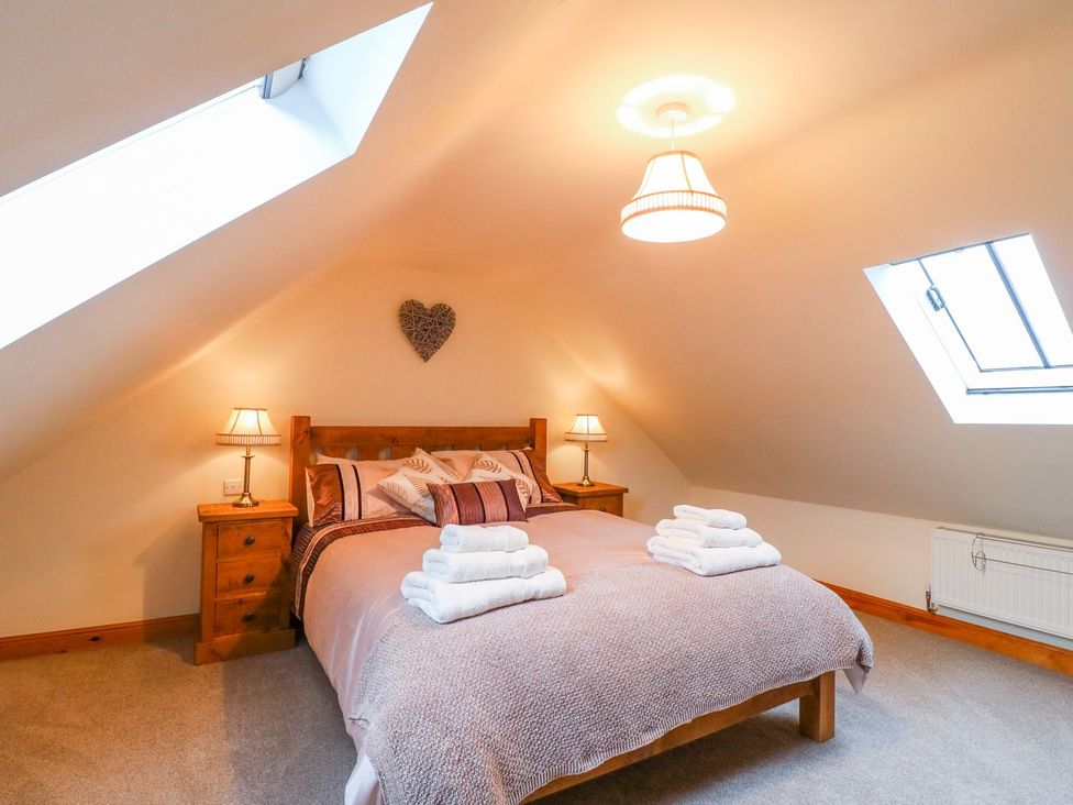 A bedroom with a bed and nightstands at The Barn in Wirksworth