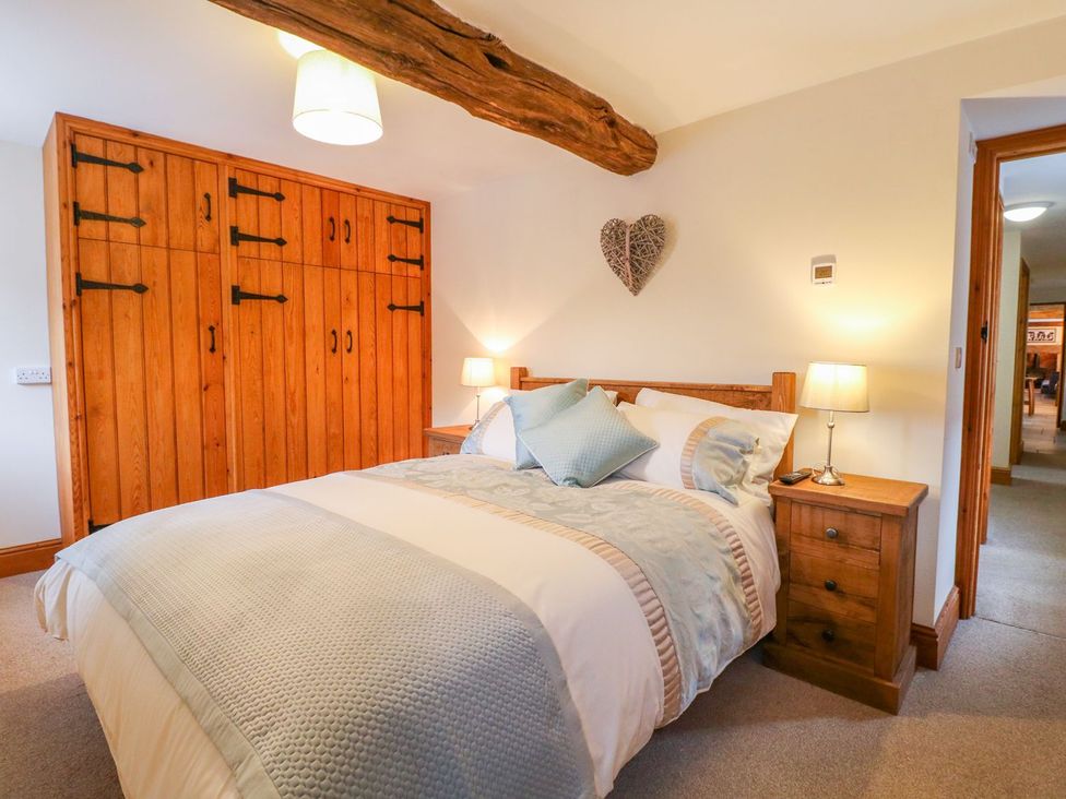 A bedroom with a bed and wardrobe at The Barn in Wirksworth