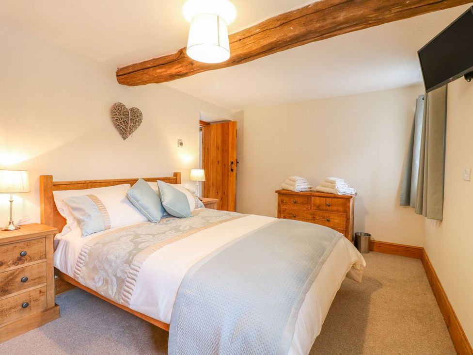 A bedroom with a bed and dresser at The Barn in Wirksworth