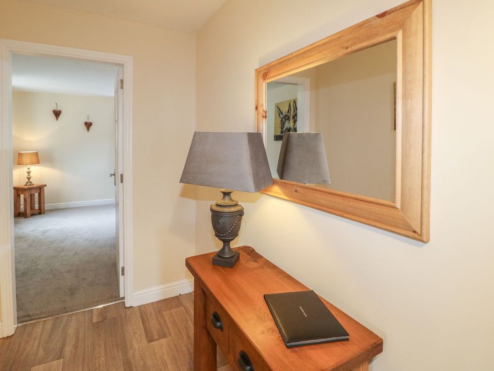 A hallway with a table and lamp at The Lodge in Wirksworth