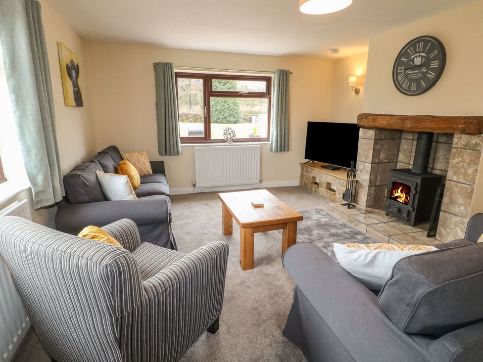 A living room with a sofa and fireplace at The Lodge in Wirksworth