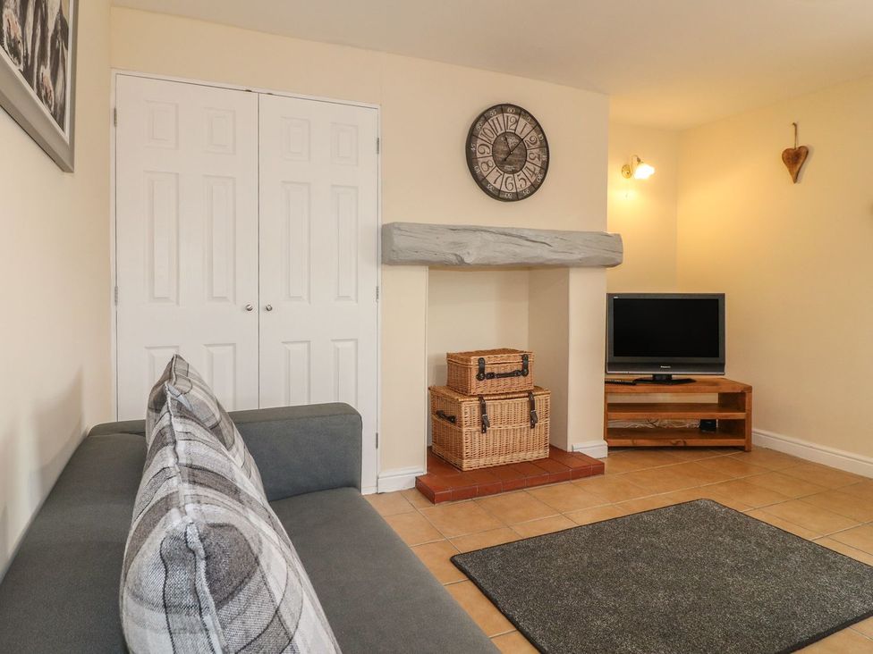 A living room with a sofa and television at The Lodge in Wirksworth